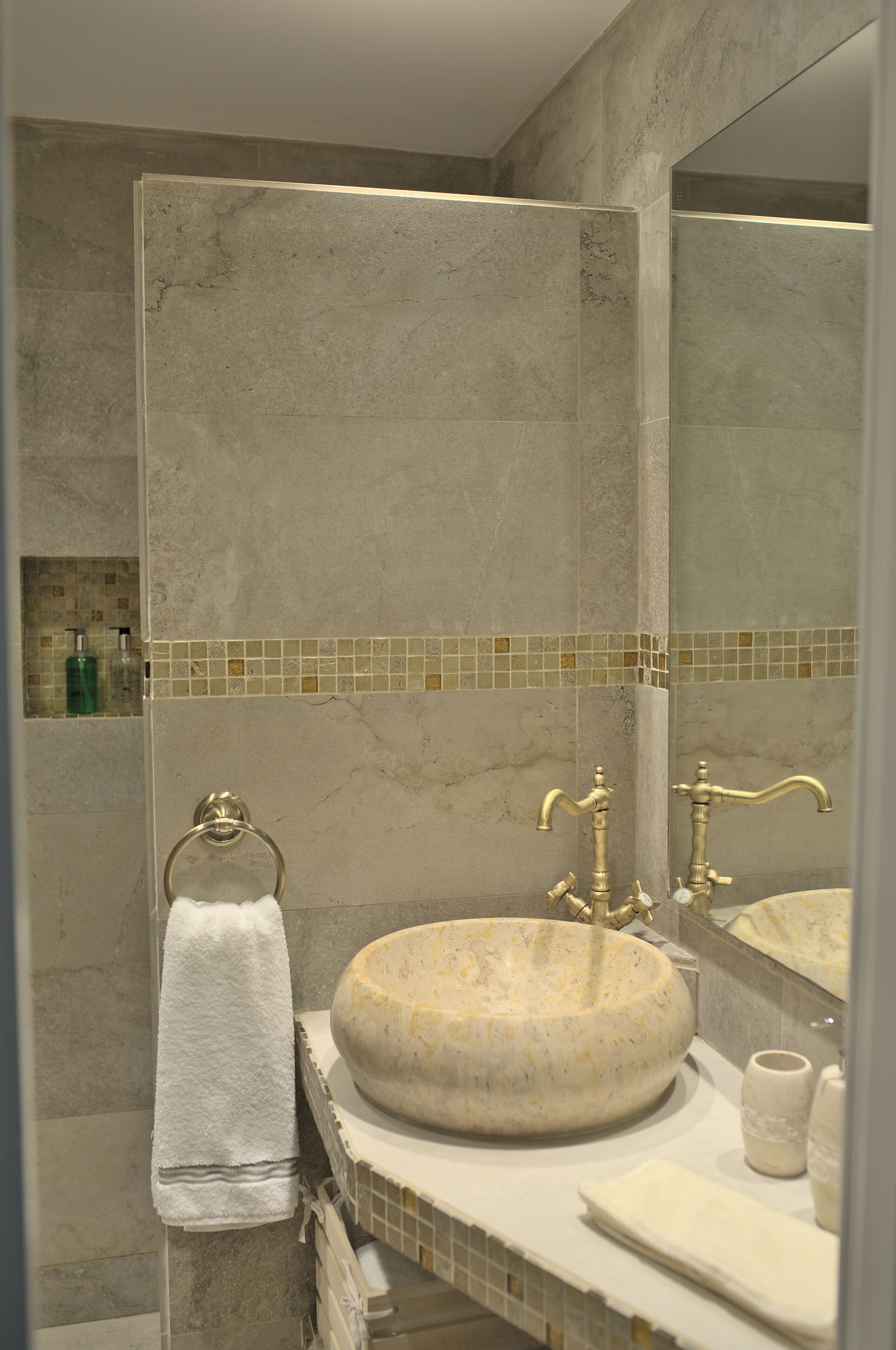 A bathroom with a marble sink, a towel rack, and a mirror.