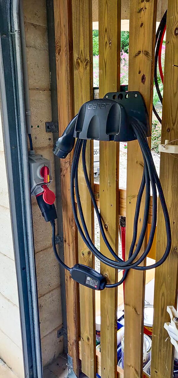 A portable generator mounted on a wooden fence, connected to a power outlet. - Le Hibou Heureux - Beautiful Villa for 8 With Private Pool and Garden/Parking (Bézenac)