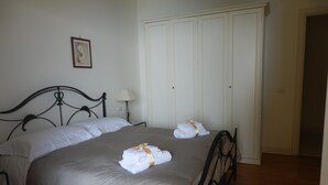 A neatly made bed with a grey bedspread and white pillows, a bedside lamp, and a framed picture on the wall. - Fantastic apartment, Taormina with swimming pool, 5 minutes from Greek theater  (Taormina)