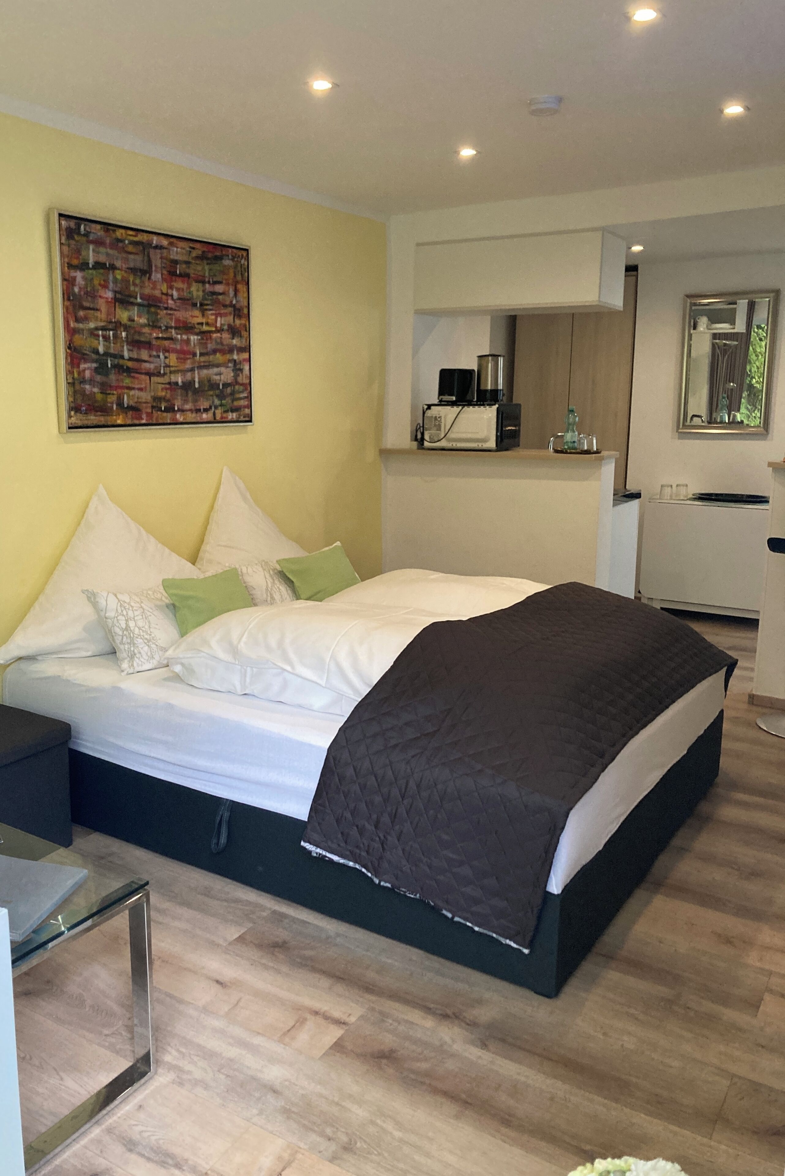 Una camera da letto moderna con un letto grande, una scrivania e un angolo cottura.