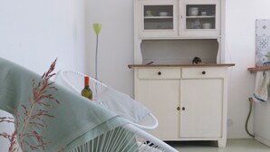A room with a white chair, a cabinet, and a small table. - Casa Mancose, vacation in the olive grove with sea views in the Cilento (Cicerale (SA))