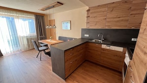 Una cucina moderna con mobili in legno, un'isola centrale e un'area pranzo con tavolo e sedie.