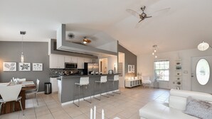 A modern kitchen with a central island, white furniture, and pendant lighting. - Contemporary Pool Villa I - just few minutes to Beach - heated Pool & Spa, WiFi! (VENICE)