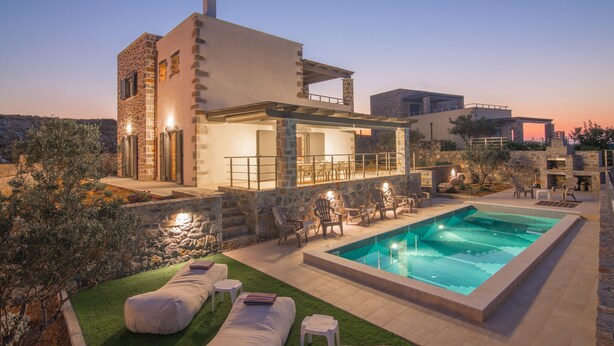 A modern house with a swimming pool, stone walls, and outdoor seating. - Charlise Luxury Villa by Cretevasion (Kokkini Hani)
