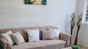 Un soggiorno con un divano, un tavolino da caffè e un quadro appeso al muro.