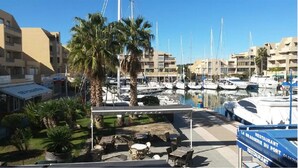 A marina with boats, a covered seating area, and a restaurant named 'LA BRASSERIE DU PORT'.