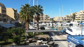 A marina with boats, a covered seating area, and a restaurant named 'LA BRASSERIE DU PORT'. - PANORAMIC SEA VIEW-LARGE air-conditioned T3-Direct beach- SWIMMING POOL-Ground floor- 7pers. CAR PARK (BORMES LES MIMOSAS)
