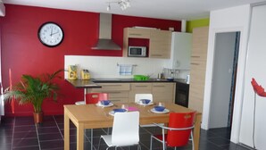 Een moderne keuken met rode wanden, een houten eettafel en een kamerplant.