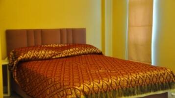 A bed with a patterned bedspread and a headboard.