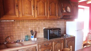 Une cuisine avec des meubles en bois, un four à micro-ondes et un pare-feu en carreaux.