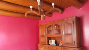 Une pièce avec un meuble en bois, un banc et un lustre.