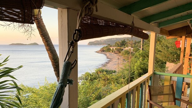 Un balcón con vista a la playa y el océano.