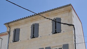 Un edificio de dos pisos con múltiples ventanas y una puerta.