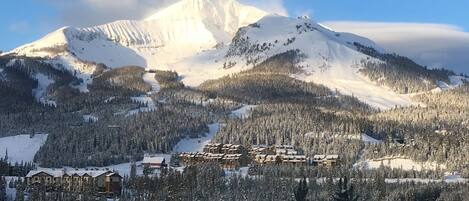 Una località montana con edifici innevati e una pista da sci.