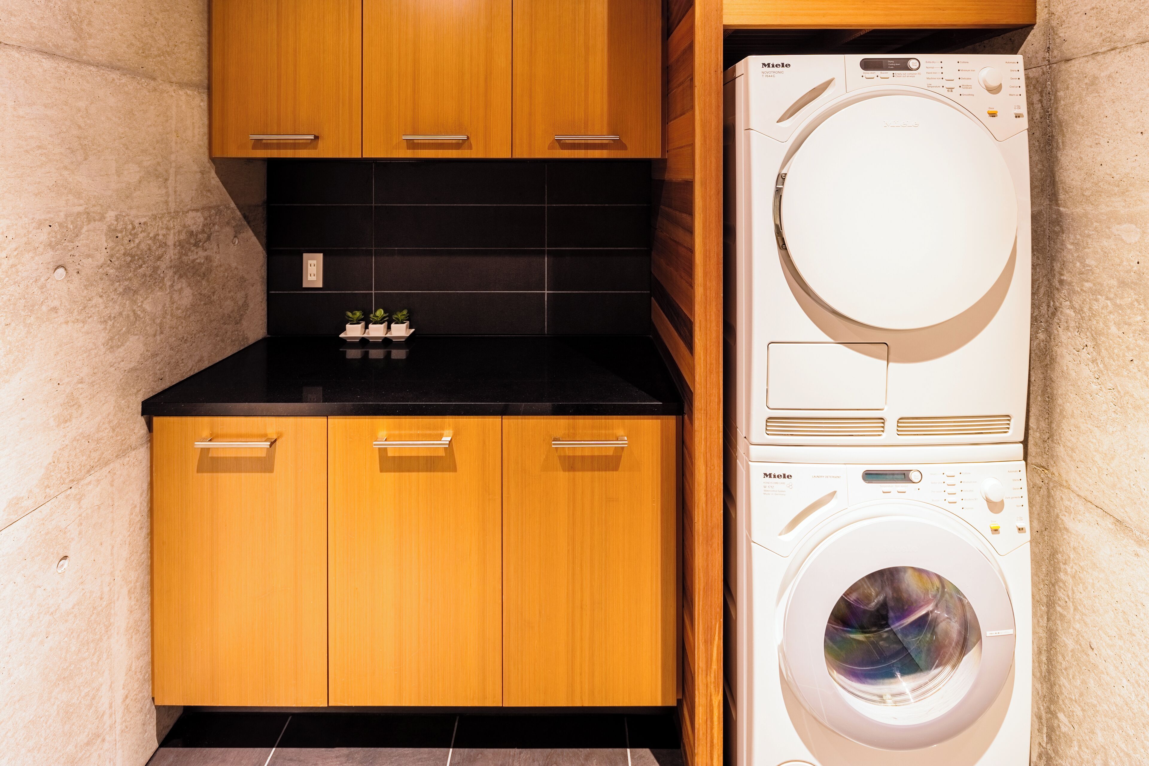 A compact kitchen with wooden cabinets and a built-in washer and dryer.