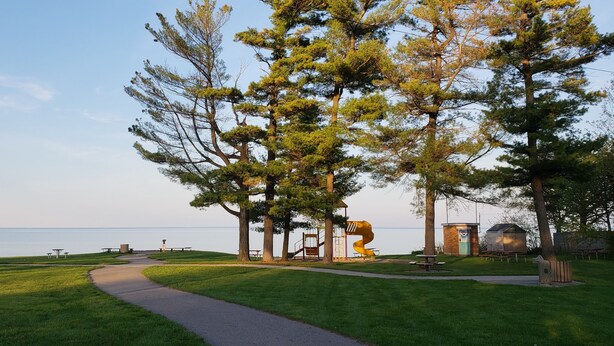 A park with a walking path, picnic tables, and a playground.
