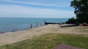 A beach with a wooden deck, a sandy shore, and a calm sea.