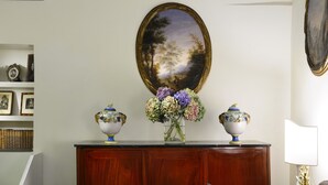 A room with a wooden cabinet, a framed painting, and a vase with flowers. - Close To Piazza Navona, Historic, Charming & Romantic Flat, 2 Bath, AC, Wi-Fi (Roma)