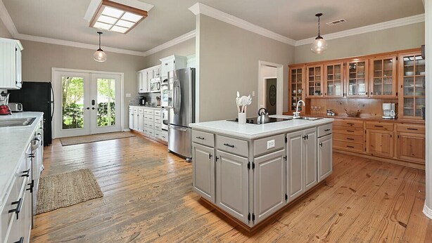 A spacious kitchen with a central island, wooden cabinets, and a large window. - Rambling Ranch ~ The Ultimate Gathering Place! (College Station)