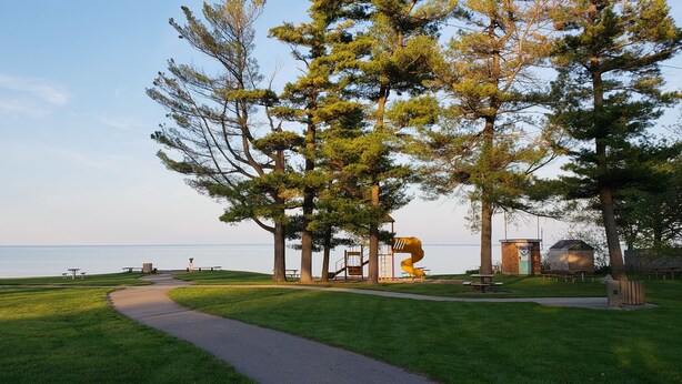 A park with a walking path, picnic tables, and a playground. - The Beach House Cottage (Fort Gratiot Twp)