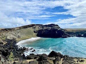 A coastal landscape with rocky terrain and a clear blue sky. - Beach Front Condo (Ocean View), Best Snorkeling/Surfing. (Kailua-Kona)