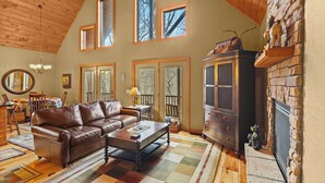 Ein gemütliches Wohnzimmer mit Ledersofa, Couchtisch aus Holz und Kamin.