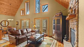 A cozy living room with a leather sofa, a wooden coffee table, and a fireplace.