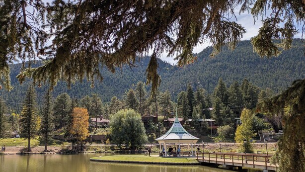 A lakeside view with a gazebo, picnic table, and houses in the background. - CASCADE RETREAT MOUNTAIN VIEWS, GREAT LOCATION NEAR COLORADO SPRINGS ATTRACTIONS (Cascade-Chipita Park)