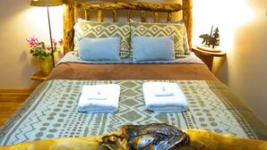 A bed with a wooden headboard, two pillows, a blanket, and two folded towels. - CASCADE RETREAT MOUNTAIN VIEWS, GREAT LOCATION NEAR COLORADO SPRINGS ATTRACTIONS (Cascade-Chipita Park)