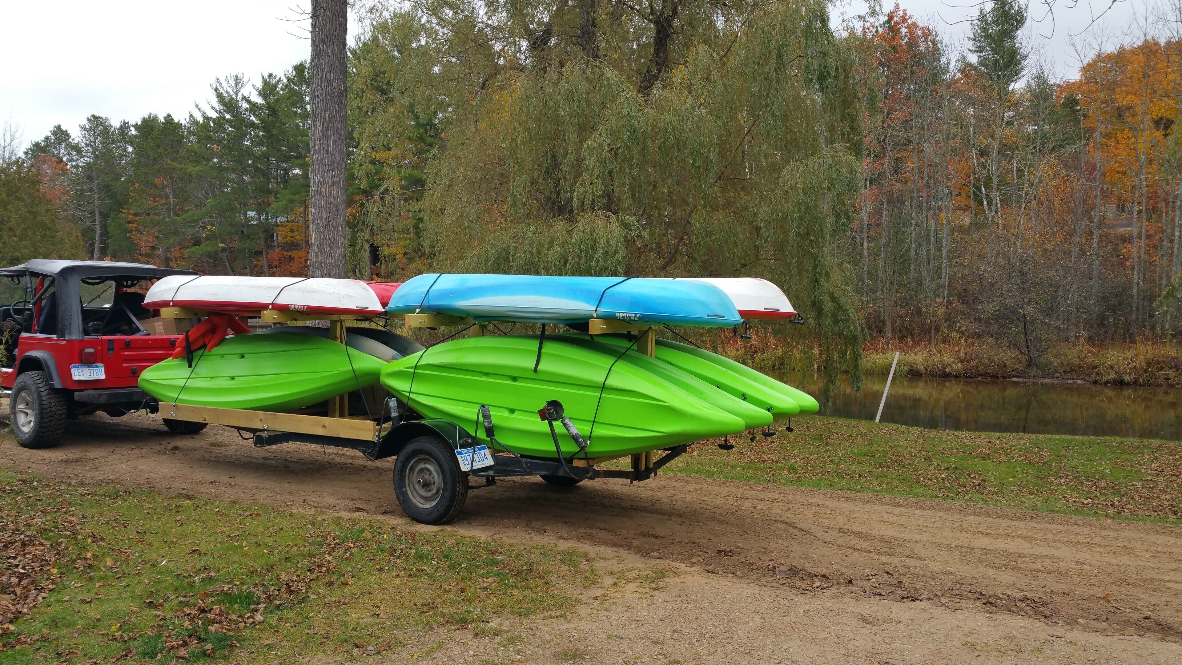 Un véhicule rouge transportant des kayaks équipés de toits.