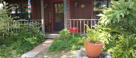 A wooden house with a porch, a mailbox, and a number '212' sign.