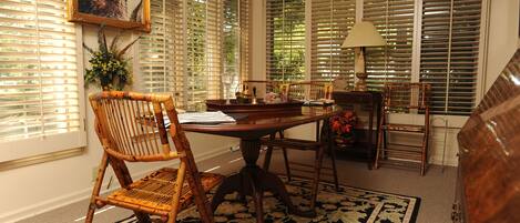 A dining area with a table, chairs, and a lamp.
