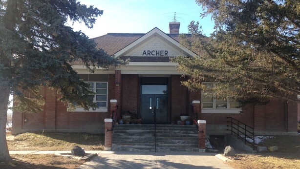 Un edificio de ladrillo con un letrero que dice "ARCHER" en la entrada.