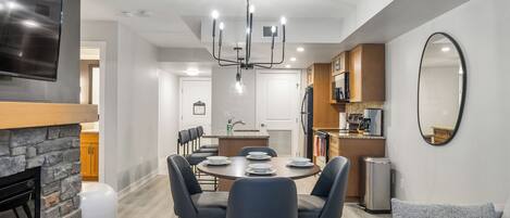Et moderne køkken med spiseplads, indbygget ovn og et stort spejl.