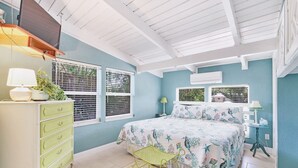Une chambre à coucher avec un lit, une commode et des fenêtres.