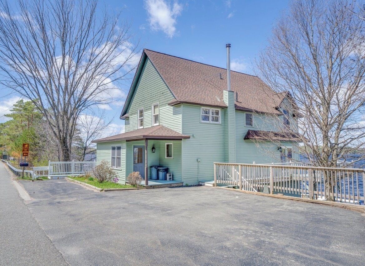 A two-story house with a front porch, a garage, and a fenced yard.