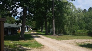 A dirt path leading to a row of cabins with a picnic table nearby.