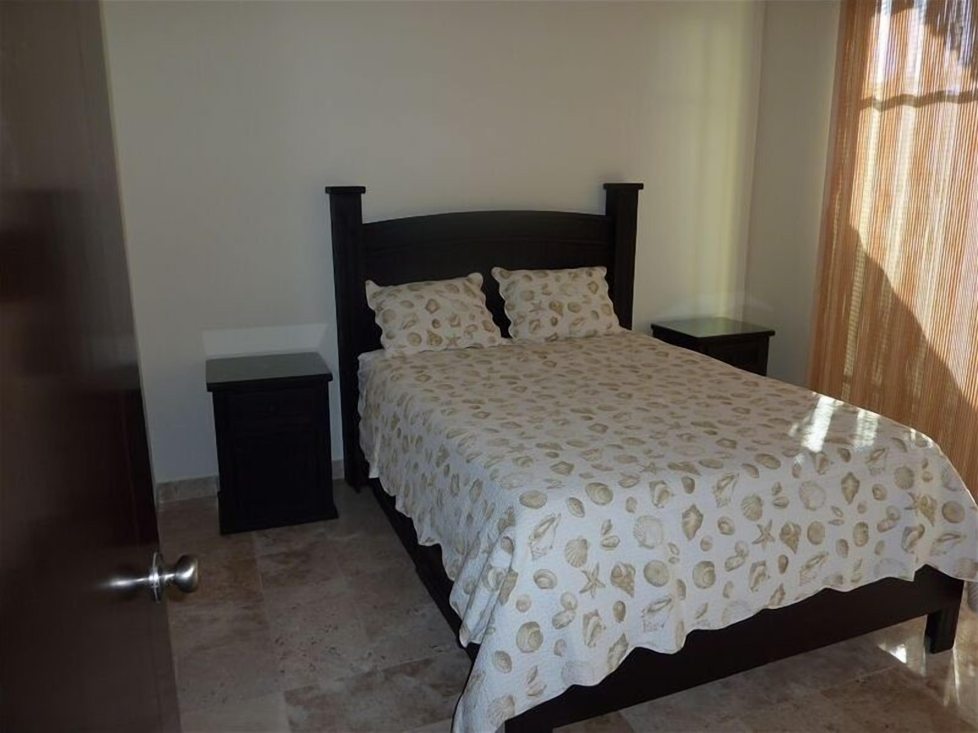 Una camera da letto con un letto, due comodini e una porta.