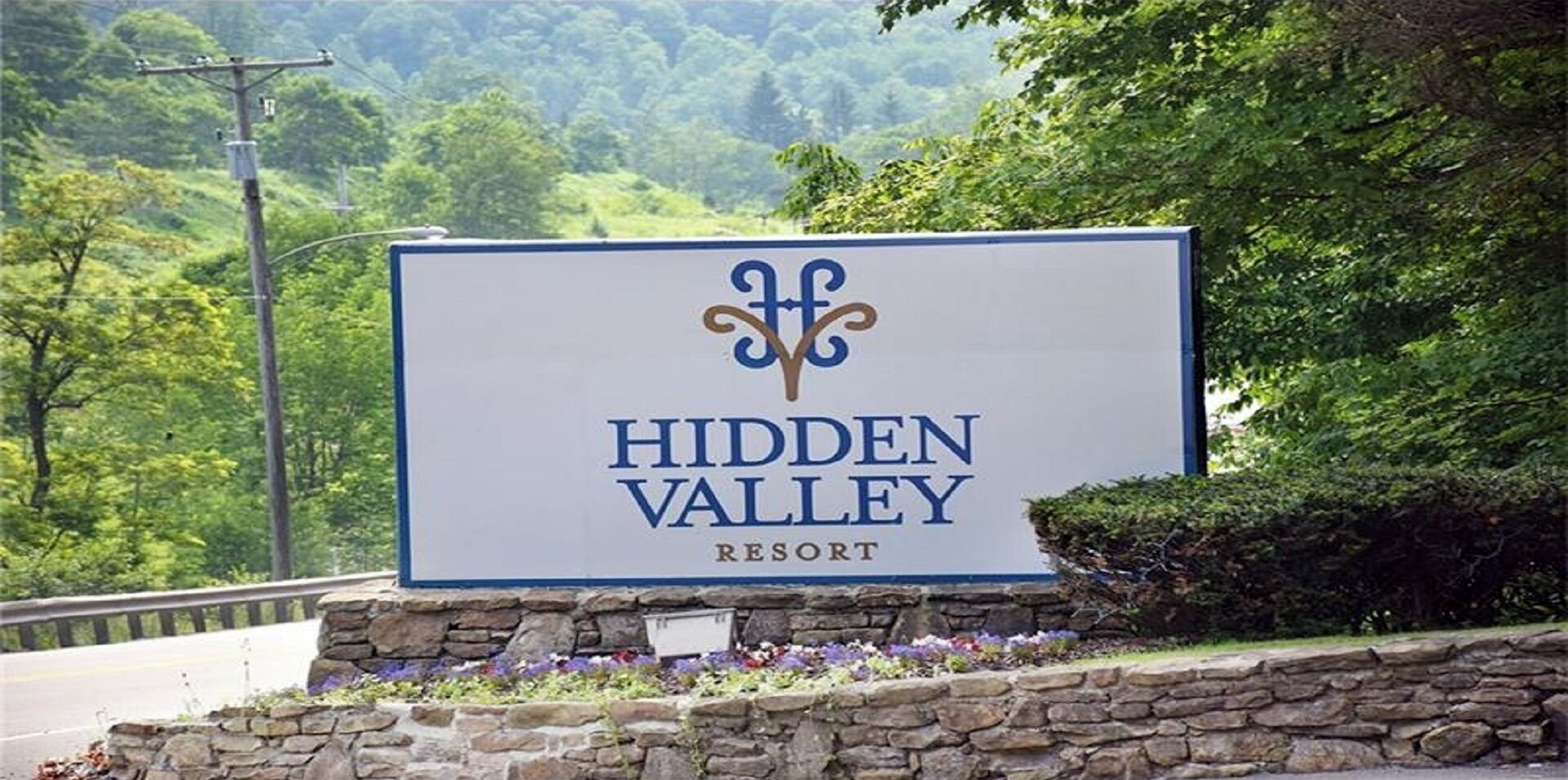 A sign for Hidden Valley Resort with a logo and the resort name.