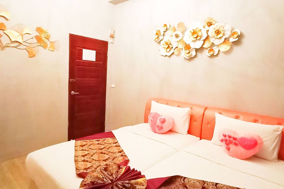 A bedroom with a bed, a nightstand, and decorative wall art.