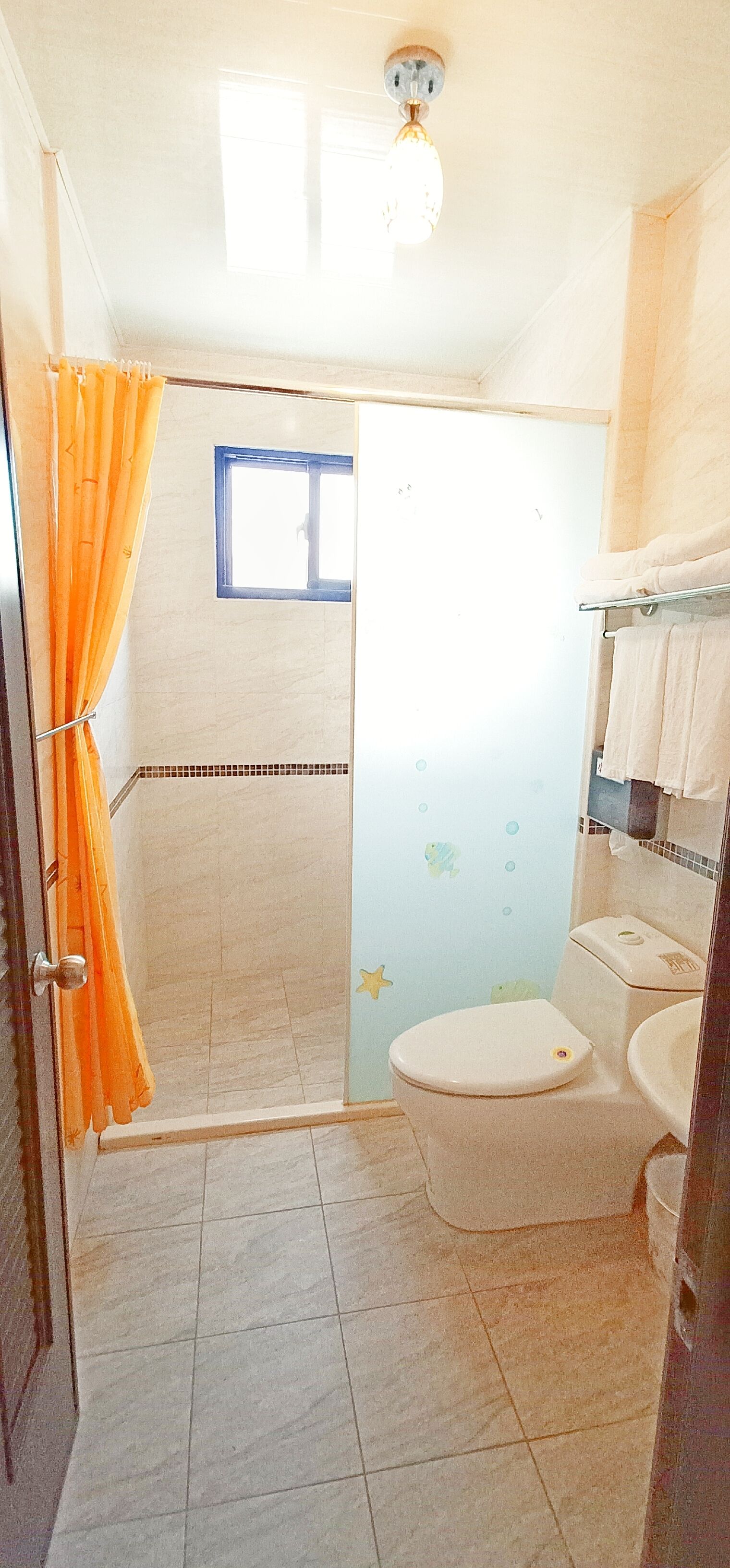 A bathroom with a shower, toilet, and sink.