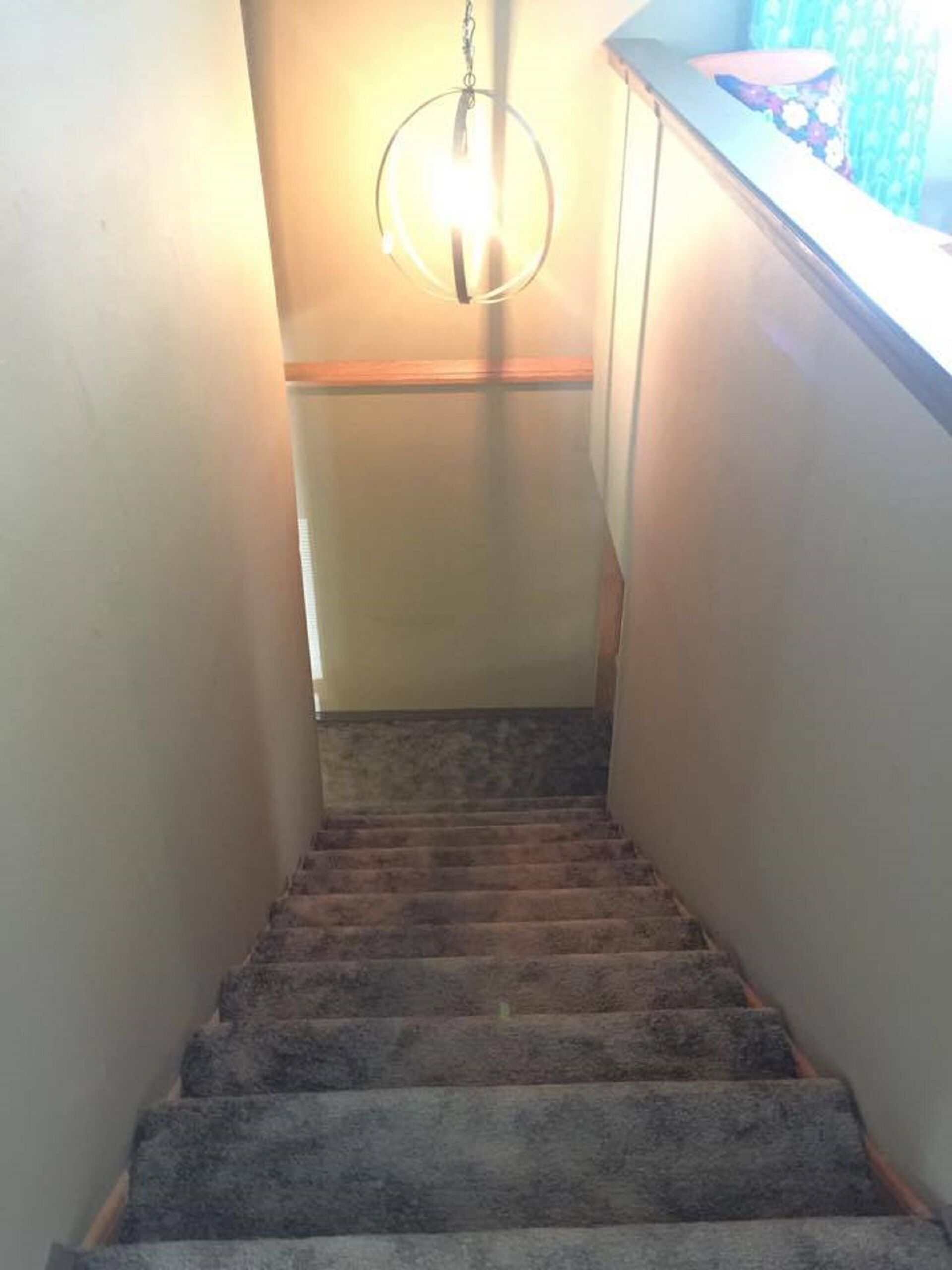 Eine Teppich-verlegte Treppe mit einer Leuchte an der Oberseite.