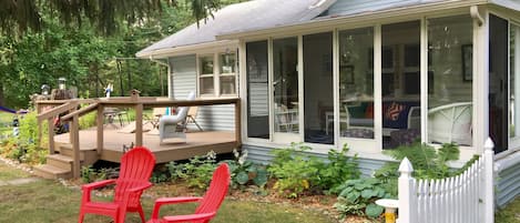 A house with a covered porch, a deck, and a fenced yard.