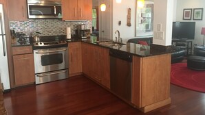 Una cocina moderna con armarios de madera, electrodomésticos de acero inoxidable y una isla central.