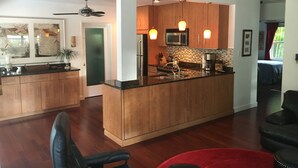 Una cocina moderna con armarios de madera, una isla central e iluminación colgante.