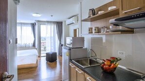 Een moderne keuken met een zwart aanrecht, een roestvrijstalen spoelbak en een kom verse groenten.