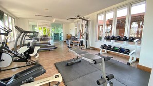 Een sportschool met loopbanden, een bankdrukapparaat en gewichten.