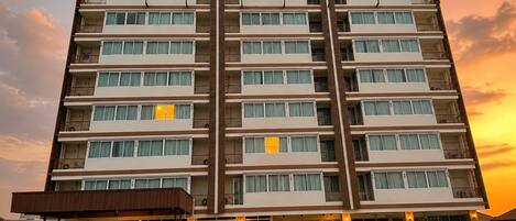 A multi-story hotel with a prominent 'WINNER' sign, a covered entrance, and a parking lot.