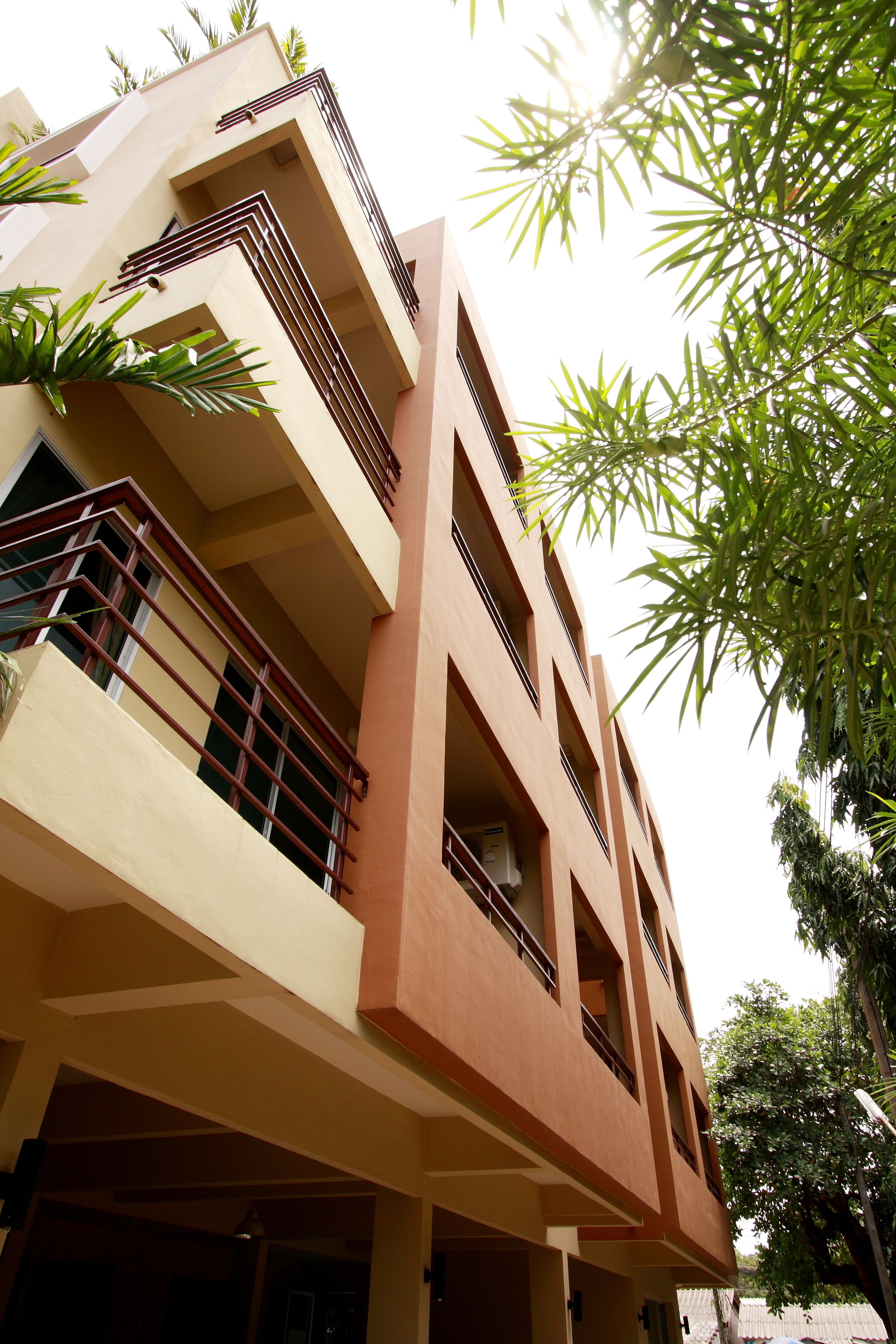 A multi-story building with balconies, a flat roof, and a clear sky.