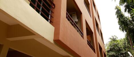 A multi-story building with balconies, a flat roof, and a clear sky.